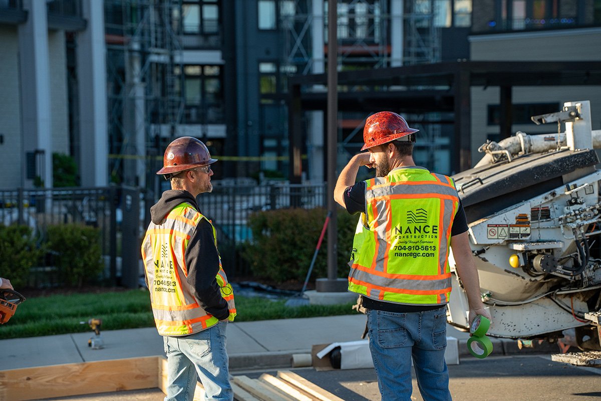 Two contractors reviewing commercial construction drawings on site