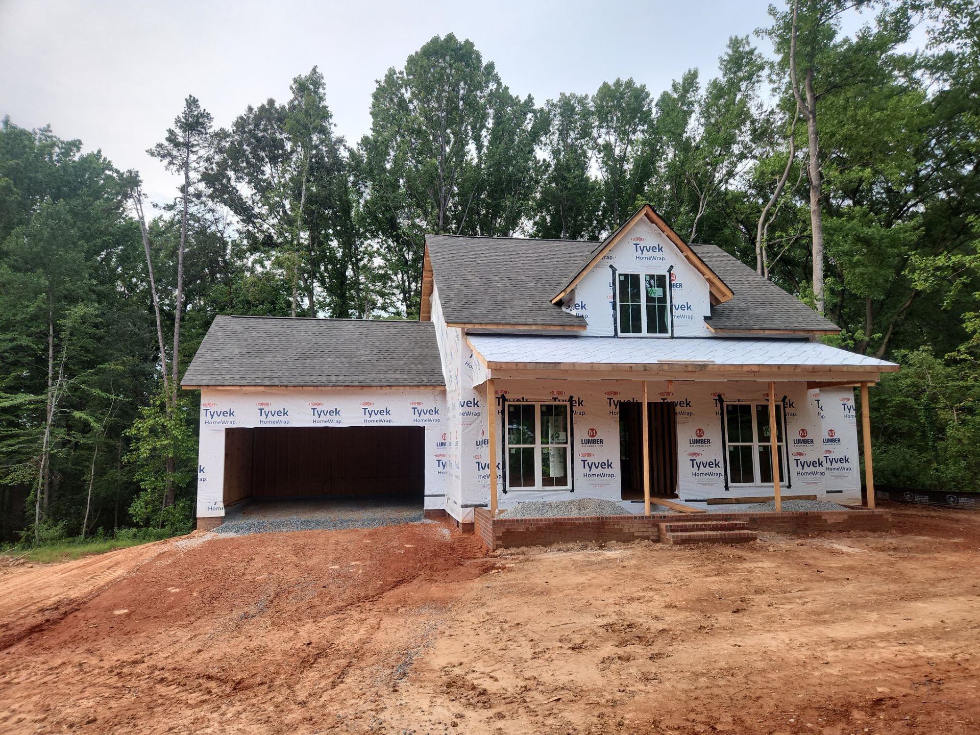 New residential home under construction with exterior framing and weather barrier installed by Nance Construction New residential home under construction with exterior framing and weather barrier installed by Nance Construction